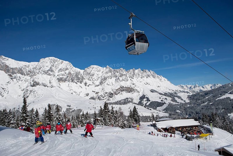 Skiers on ski slope in front of mountain scenery