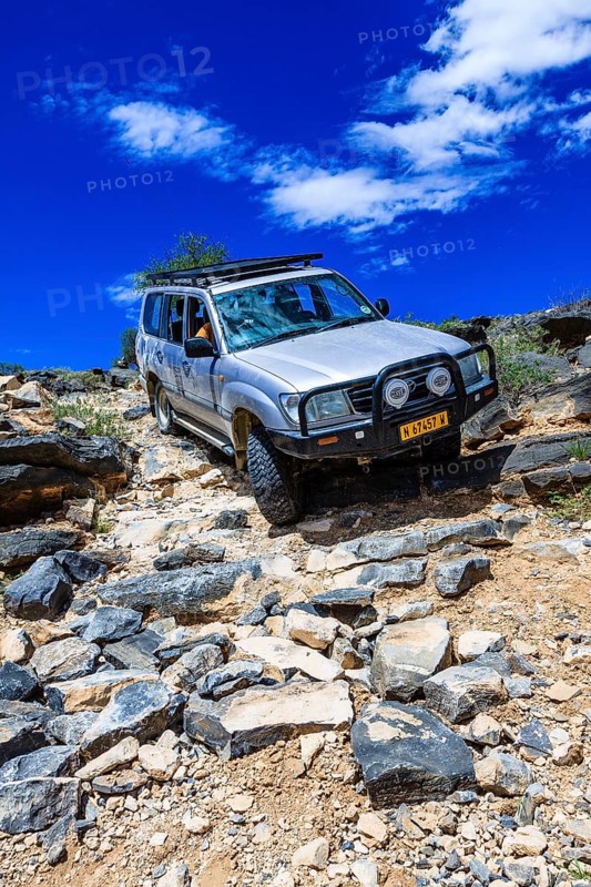 SUV driving down steep rock steps