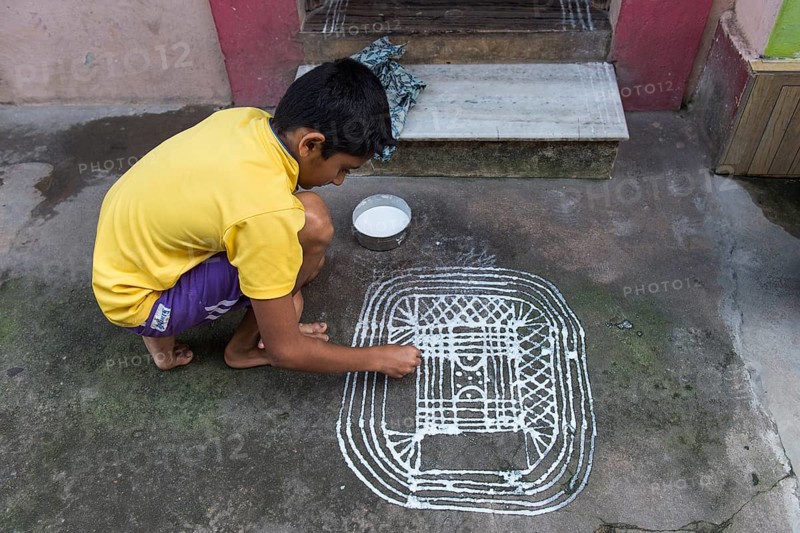 Boy painting a traditional Rangoli