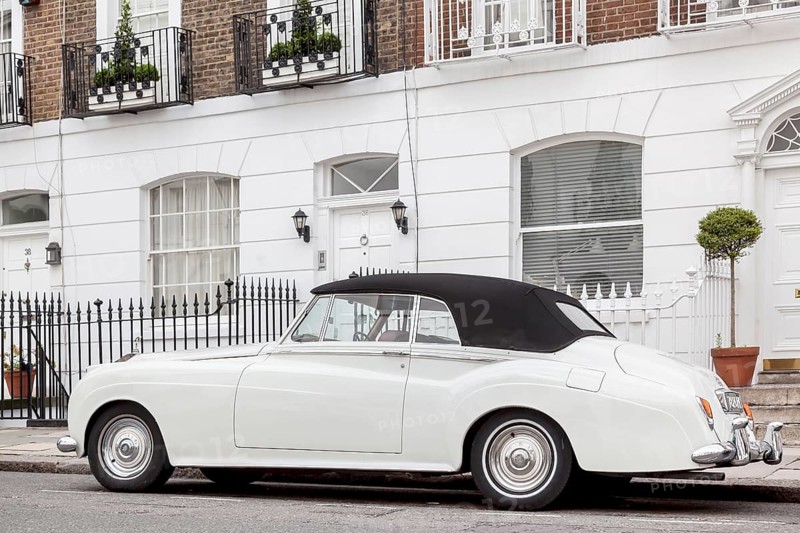 A Rolls Royce Silver Cloud parked in front of a row of houses in the exclusive district of Knightsbridge