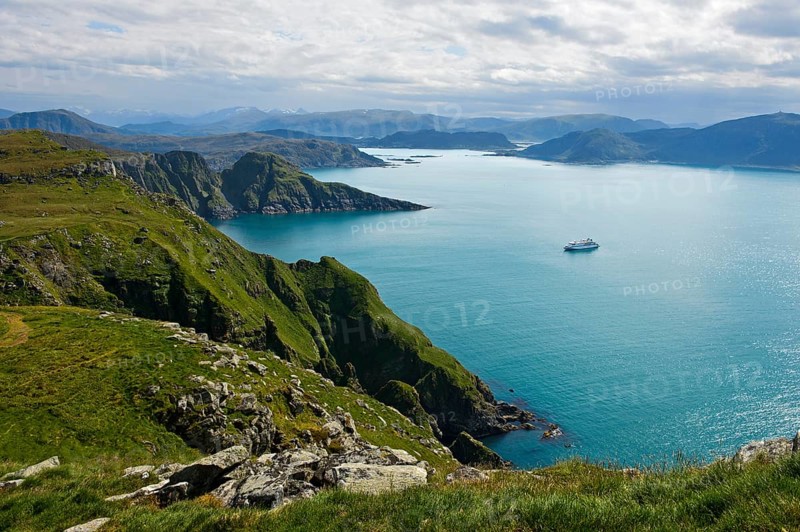 Cruise ship in a bay off the rugged cliffs of Runde island