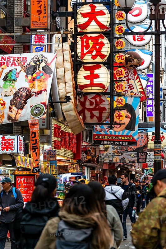 Crowd crowded in pedestrian zone with lots of advertising signs for restaurants and shopping centers
