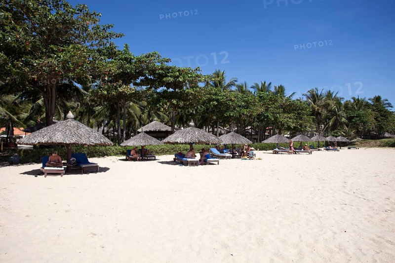 Beach with palm umbrellas at the Saigon Mui Ne Resort