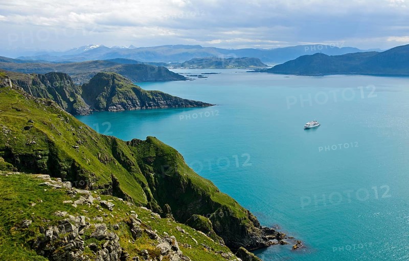 Cruise ship in a bay off the rugged cliffs of Runde island
