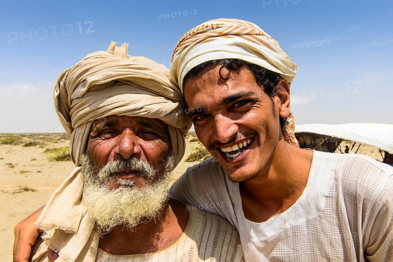 Rashaida father and son standing in front of their tent in the desert around Massaua