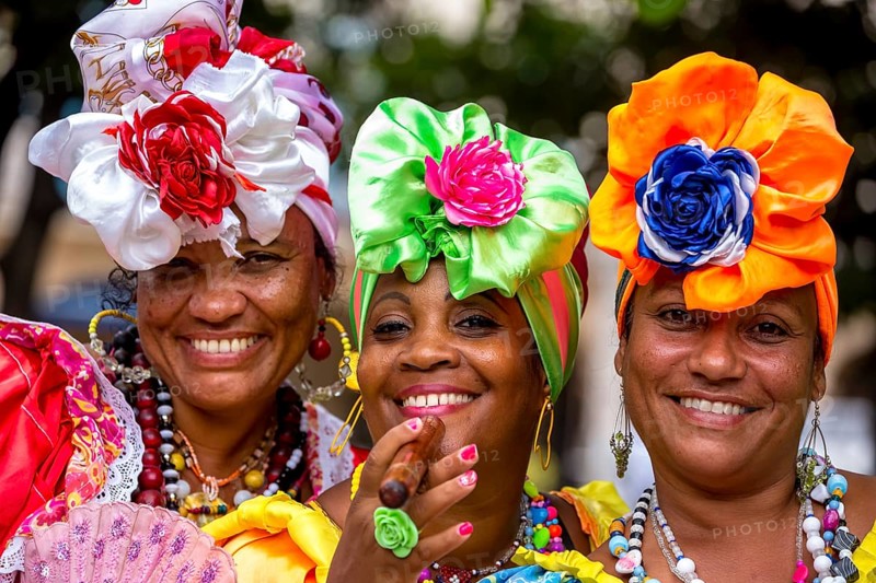 Three Cuban women in colorful Spanish-inspired costumes