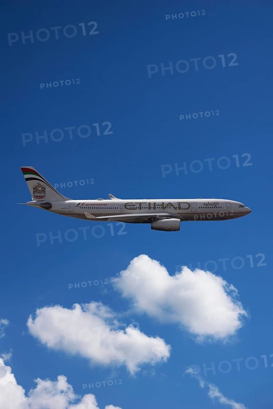A6-EYK Etihad Airways Airbus A330-243 in flight against a cloudy sky