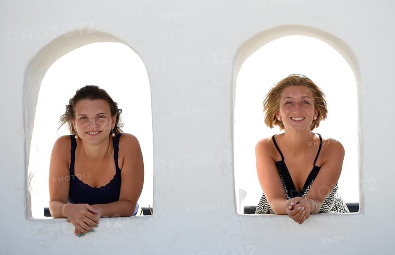 Two young women looking out from the Balcon de Femes