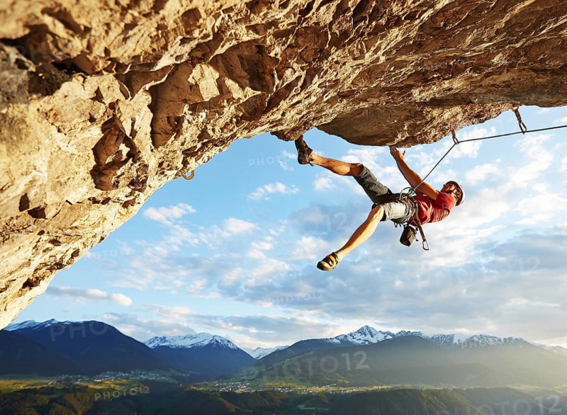Freeclimber with helmet climbing on a rock face