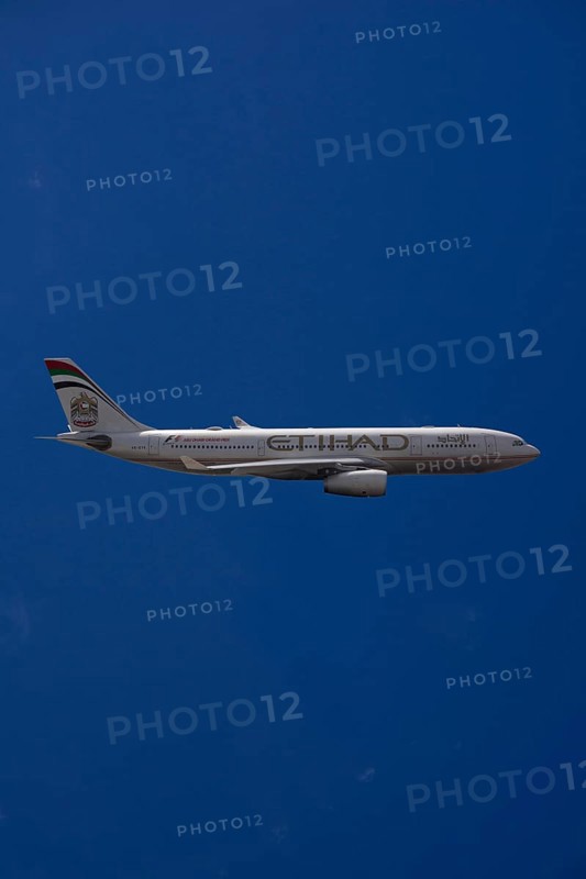 A6-EYK Etihad Airways Airbus A330-243 in flight against a blue sky