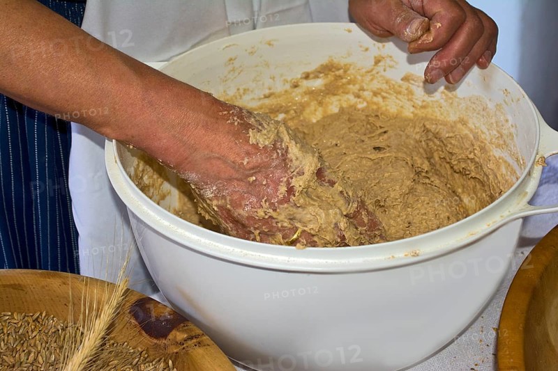 Female farmer kneading bread dough