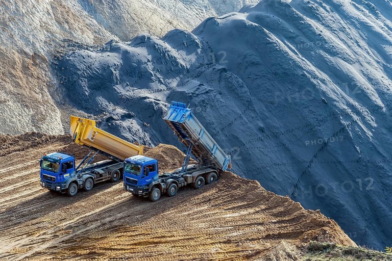 Two tipper trucks standing at the edge of the open cast mine