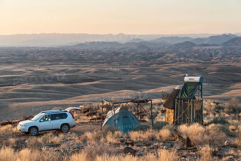 SUV next to tent and small hut