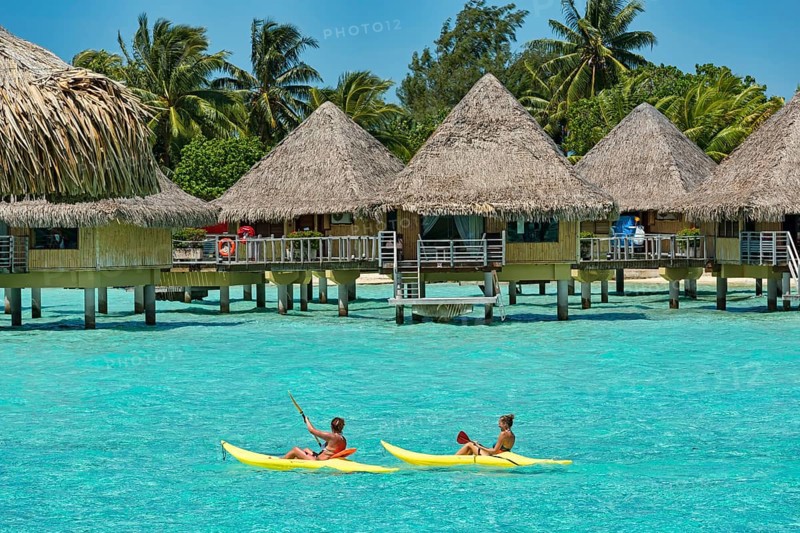 Paddlers in front of overwater bungalows