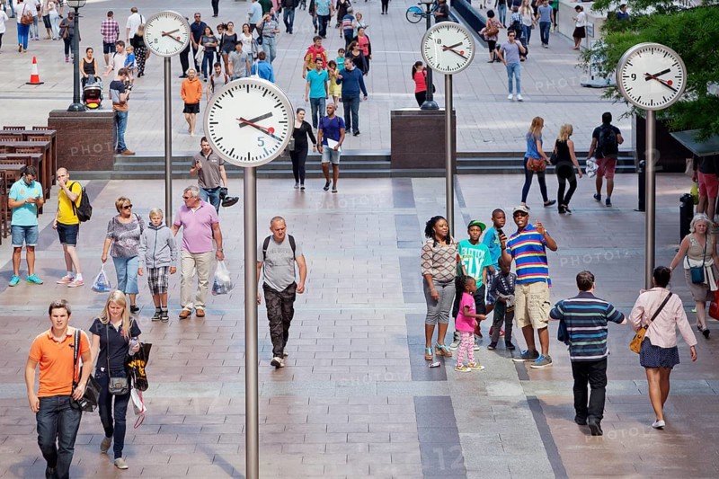 People in a square with clocks