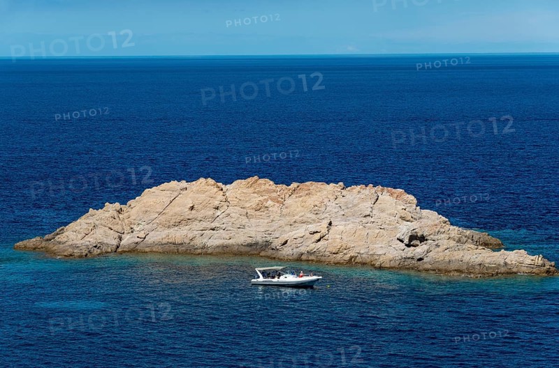 Motorboat in front of rock