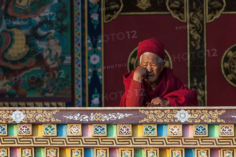 Buddhist monk on the balcony of the Cinya Llama Gompa
