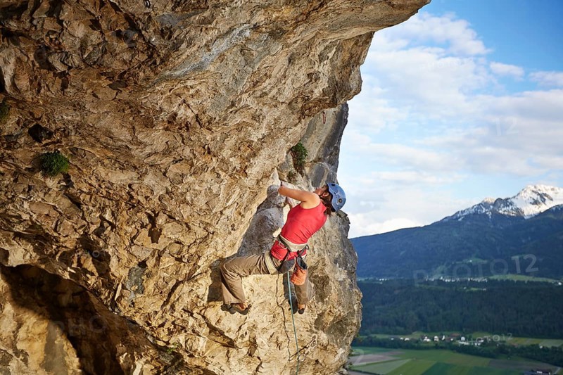 Freeclimber with helmet climbing on a rock face