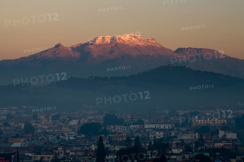 The volcano Iztaccihuatl in early morning light with city
