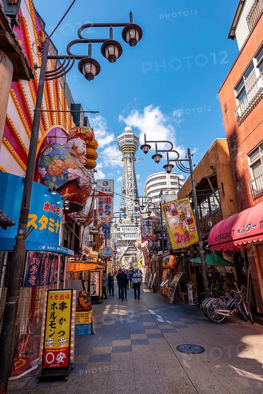 Many colorful advertising signs in a pedestrian zone with shops and restaurants