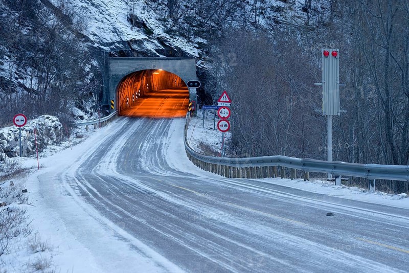 Wintry road and lit tunnel