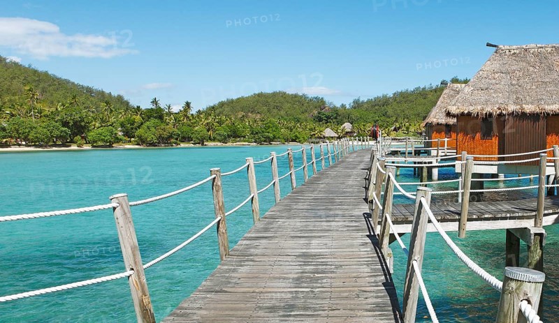 Wooden walkway to overwater bungalows in the sea