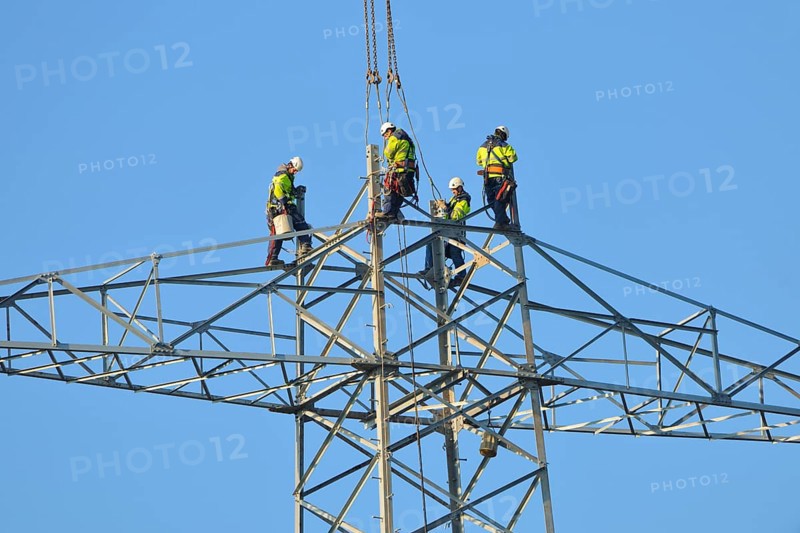 Overhead linemen working on a pylon