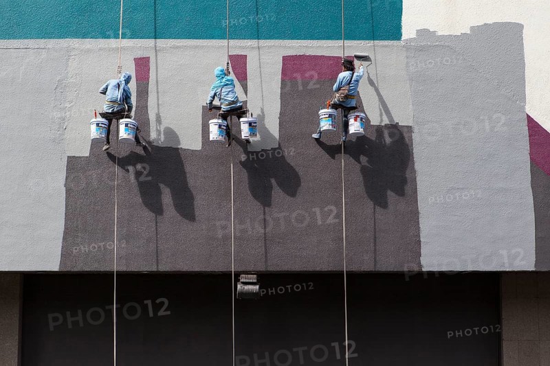 Decorators painting the facade of a high-rise building