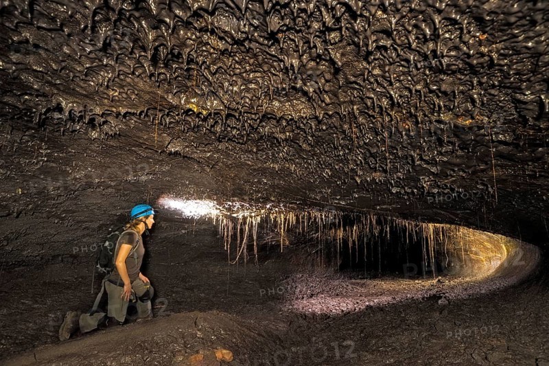 Tourist in a subterranean lava tube created by an eruption of the Piton de la Fournaise volcano