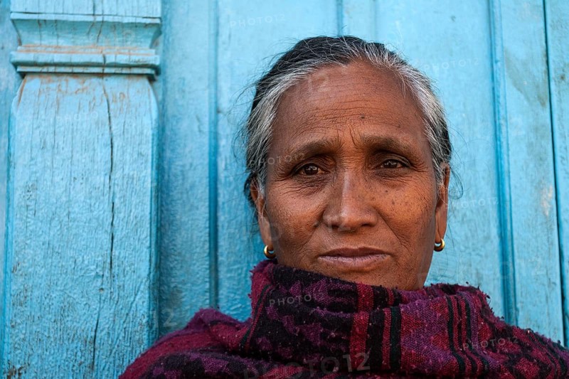 Nepalese woman in front of a blue door