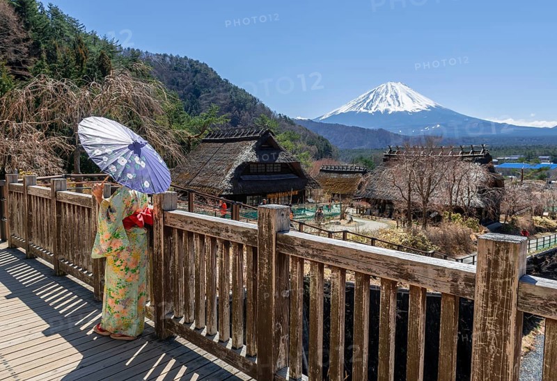 Japanese woman in kimono with paper umbrella in the open-air museum Iyashinosato
