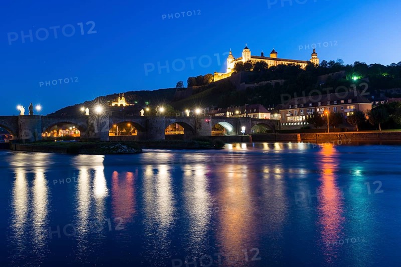 The illuminated Festung Marienberg castle located on a hill above the town