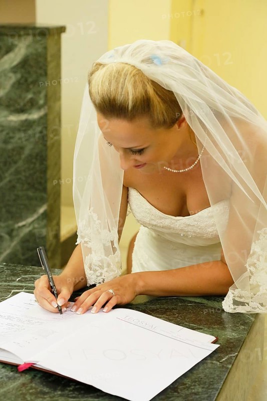 Bride signing the church register after the ceremony