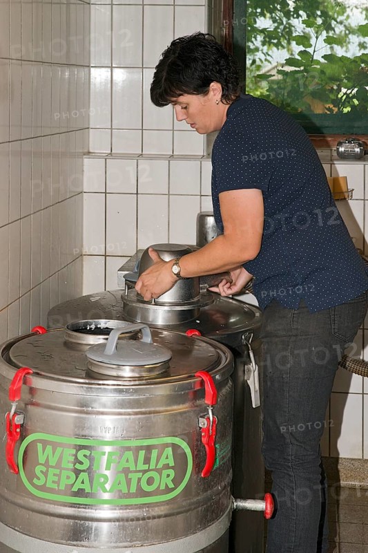 Young farmer filling milk into transport tanks