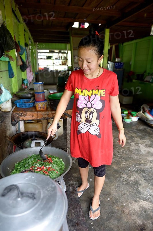 Young woman cooking in a simple restaurant