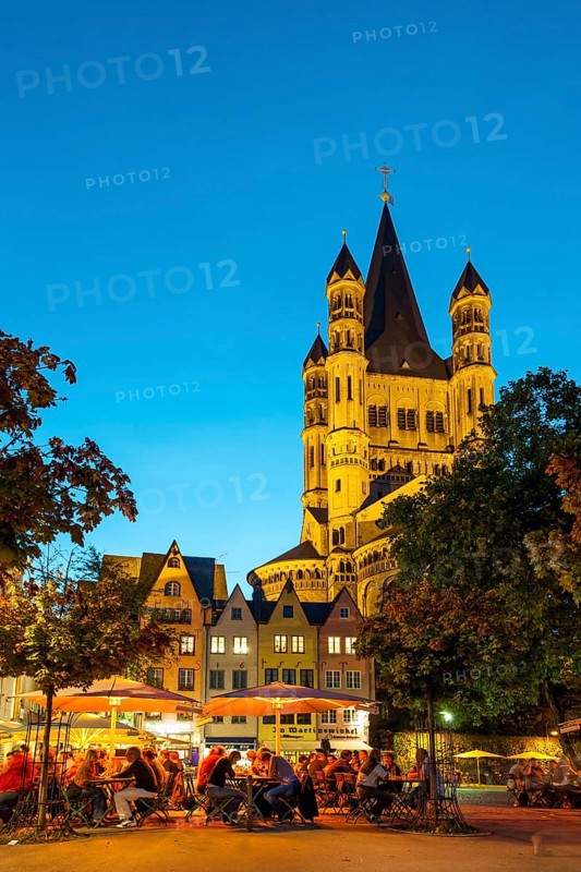Outdoor cafes in Fischmarkt square with Great St. Martin Church in the evening