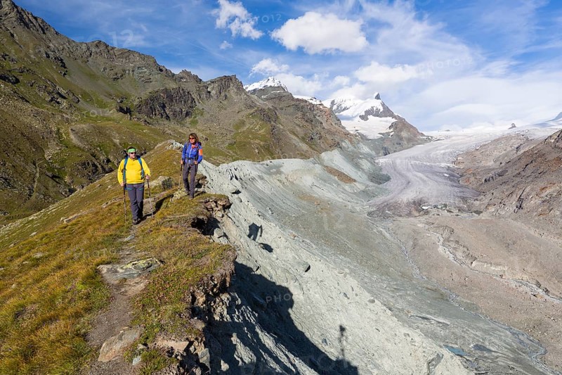 A man and a woman hiking on the moraine of the Findel Glacier at Fluhalp