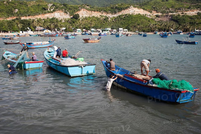 Fishermen in their fishing boats unloading their catch