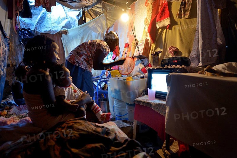 Woman and children in a ramshackle hut