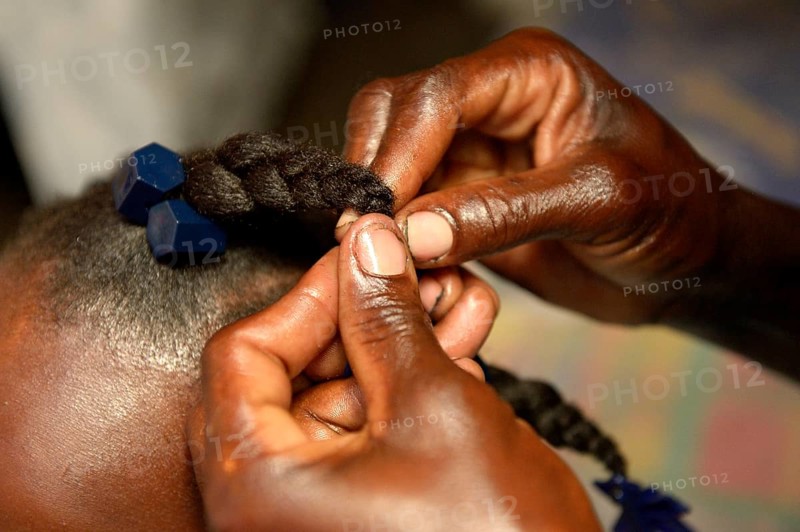Mother braiding her daughter's hair