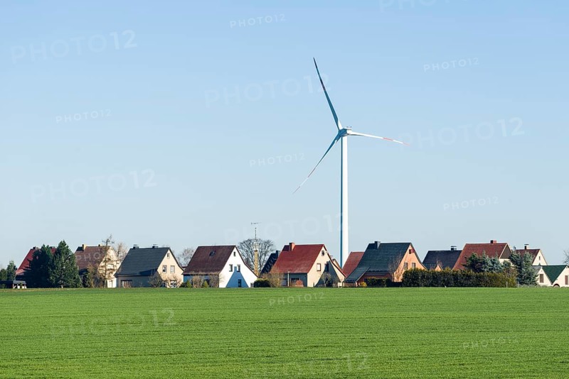Wind turbine by village with houses in an agricultural landscape