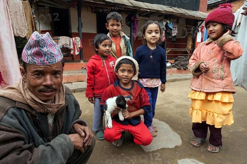 Nepalese father and children in front of their house