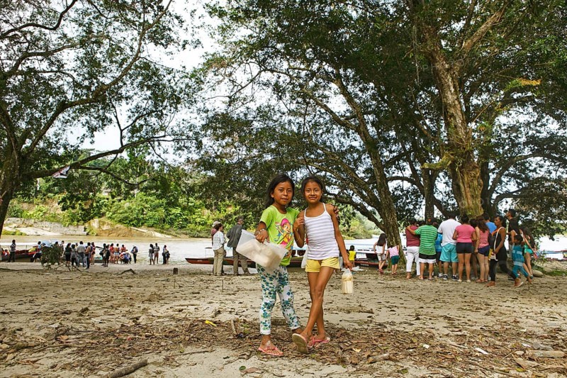 Girls selling sugar cane on the jungle beach of Misahualli