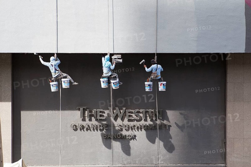 Decorators painting the facade of a high-rise building