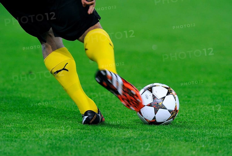 Legs of a BVB player with adidas Champions League Ball