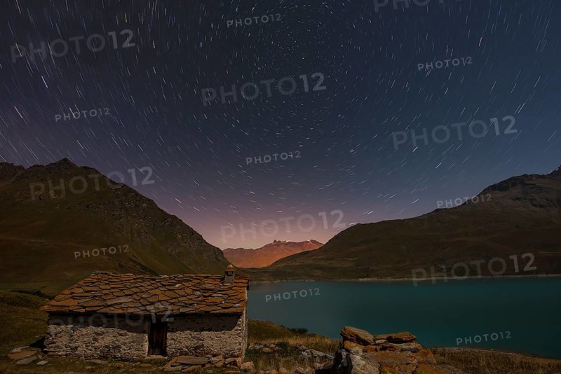 Night sky above Mont Cenis lake and a hut