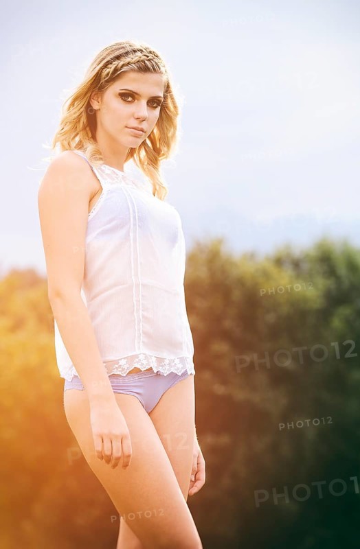 Young woman in lingerie posing outdoors
