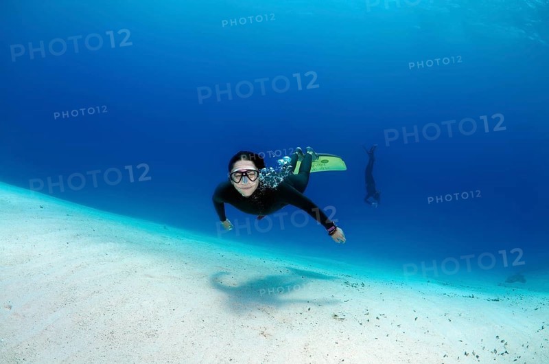 Freediver above sandy bottom