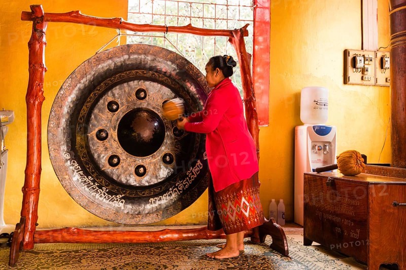 Monk using a Gong during the prayer