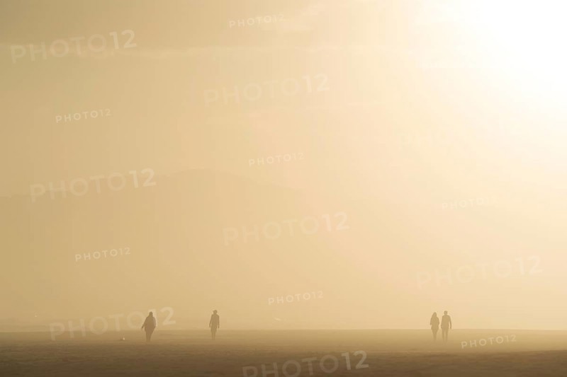 People walking at the beach at sunset